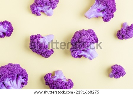 Pattern with purple cauliflower florets on yellow background.