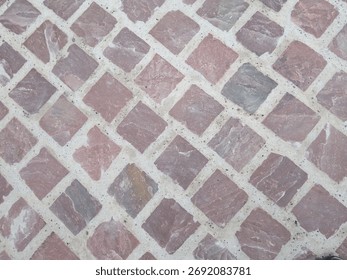 Pattern of red regular sandstone blocks as paving for the footpath, Alsace, France
