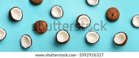 Pattern with ripe coconuts on blue background. Top View. Copy Space. Pop art design, creative summer concept. Banner. Half of coconut in minimal flat lay style