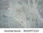 Pattern of silt and mud flow in dirty stream in Alaska.