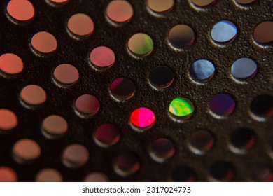 Pattern of small circles, through which a series of colored lights pass.