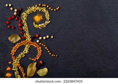 Pattern of spices on a black stone table. A set of spices from India. Decoration design. Various spices, peppers and herbs close-up top view. A set of peppers and spices for cooking.