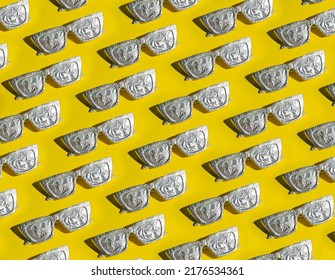 Pattern Of Sunglasses In Aluminum Foil On A Yellow Background. Minimal Summer And Sun Protection Concept.