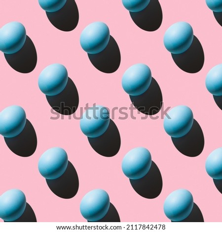 The pattern of their blue eggs with a hard shadow arranged diagonally on a pink background. Minimalistic abstract Easter background.