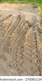 pattern of tyre wheel marks or tracks left on piles of sand at the construction site.