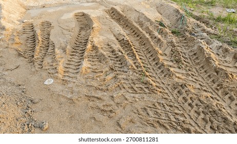 pattern of tyre wheel marks or tracks left on piles of sand at the construction site.