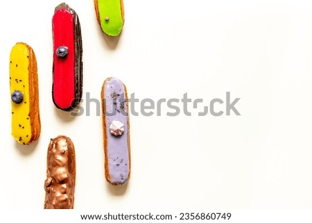 Pattern of various glased eclairs cakes. Sweet food background.