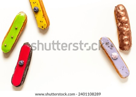 Pattern of various glased eclairs cakes. Sweet food background.