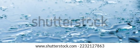 Pattern of water drops in a shiny metallic surface with table reflections