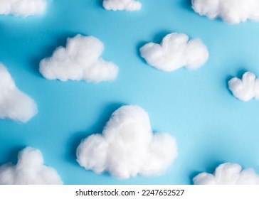 Pattern of white fluffy clouds made of cotton wool on a blue background