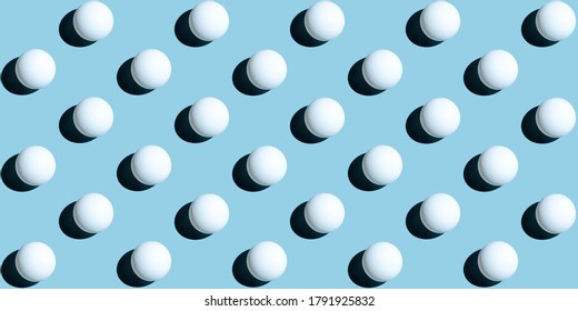 A pattern of white ping pong balls as spheres isolated on uniform blue background. Banner size.