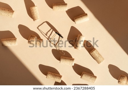 Pattern with wine and champagne corks, sun glare from a champagne bottle on a beige background with hard sunlight and shadow. Background with wooden bottle cap, top view, minimal flat lay.