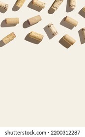 Pattern with wine corks from white and red wine on beige pastel color background with hard light and shadow at sunlight. Trend layout with bottle stoppers, wooden cork, top view, copy space