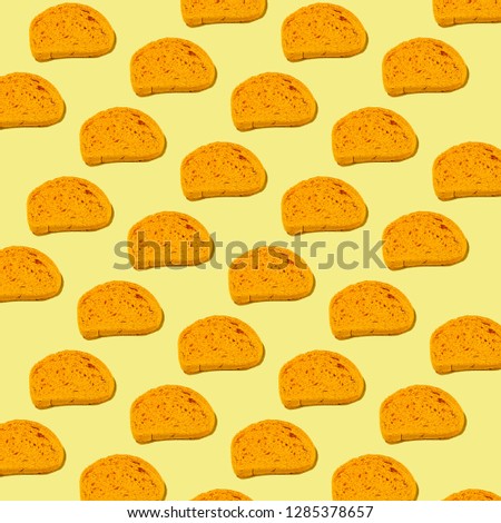Pattern of yellow slices of bread on yellow background.