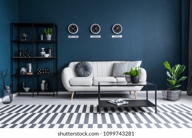 Patterned Carpet In Navy Blue Living Room Interior With Black Table In Front Of Beige Couch