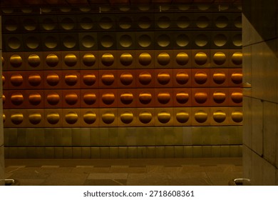 Patterned Orange Tile Wall With Repeated Circular Relief, Warm Retro Tones And Moody Lighting Form Bold Graphic Backdrop For Platform