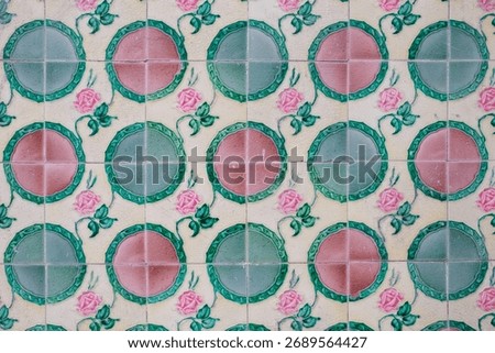 Patterned vintage ceramic wall tiles featuring alternating green and pink pastel colors and floral rose motifs, typical of Peranakan or Straits Chinese decorative architecture in Penang, Malaysia.
