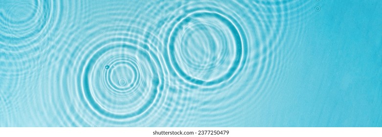 Patterns from Circles from drops on clear water Transparent blue water surface with ripples. Cosmetic moisturizing essence Banner