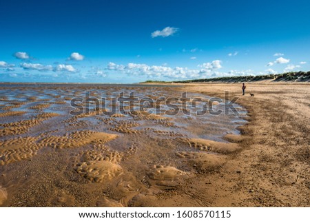 Patterns made by tide pools of water at low tide on Barnham Overy Staithe beach on Holkham bay, North Norfolk coast, East Anglia, England, UK.