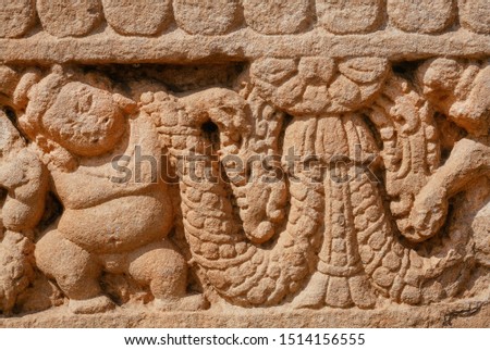 Patterns on stone relief of ansient Indian temple. Artwork on facade of sstone structure of South Indian, the 7th century.