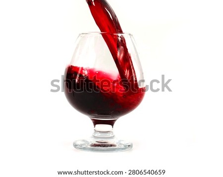 the patterns of the stream of red grape wine when poured into a glass