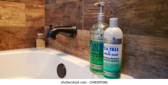 PATTON, PA/USA - NOV 2 2019:  Bottles Of Renpure Advanced Tea Tree & Lemon Sage Shampoo And Conditioner Rest On The Edge Of Tub.  