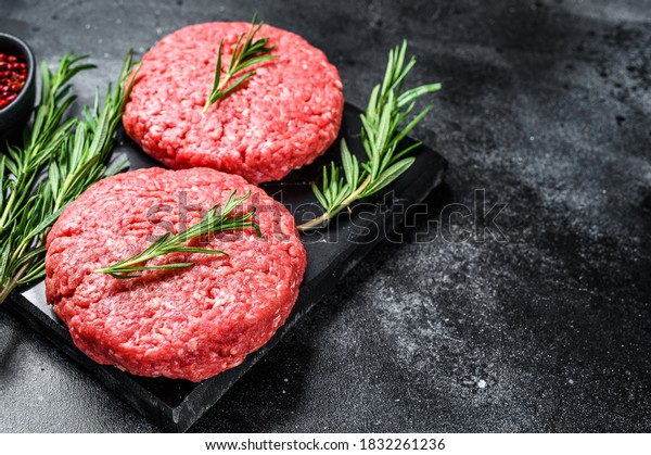 Patty of minced meat for burger. Black background.\
Top view. Copy space