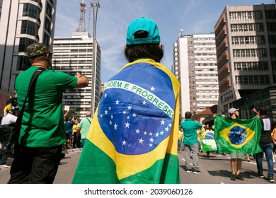 São Paulo, São Paulo, Brasil - Setembro 07, 2021: Child With His Back Dressed In The Brazilian Flag During A Demonstration On The Streets Of Avenida Paulista, Brazil.