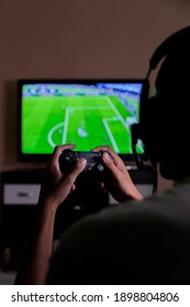 São Paulo, Brazil - Dec 28, 2020 Young Man Playing His PlayStation 4 Video Game On Television In The Living Room, Playing An Online Football Game With Friends. Plastation Concept. Game Concept.