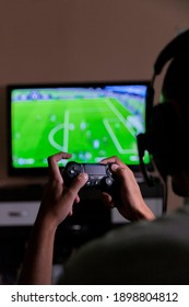 São Paulo, Brazil - Dec 28, 2020 Young Man Playing His PlayStation 4 Video Game On Television In The Living Room, Playing An Online Football Game With Friends. Plastation Concept. Game Concept.