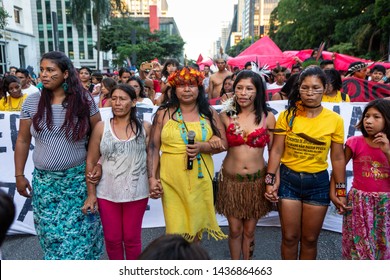 São Paulo, SP / Brazil - January 01, 2019: Indigenous Women Marching With Headdresses And Body Paintings In Protest For The Rights Of Indigenous People On Avenida Paulista. Feminism And Equality.