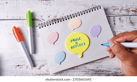 Pause and Reflect Mindfulness Concept with Hand Writing on Speech Bubble Notes and Marker Pens