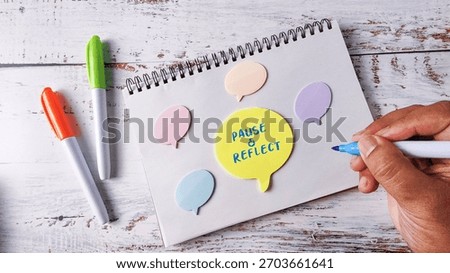 Pause and Reflect Mindfulness Concept with Hand Writing on Speech Bubble Notes and Marker Pens