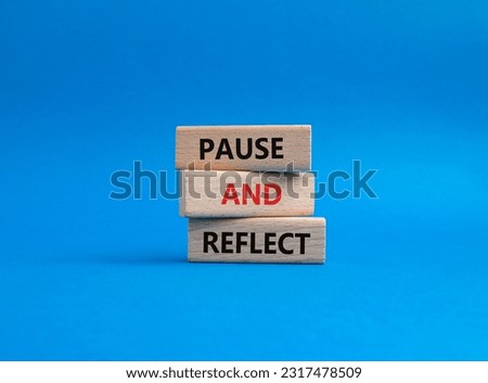 Pause and Reflect symbol. Concept words Pause and Reflect on wooden blocks. Beautiful blue background. Business and Pause and Reflect concept. Copy space.