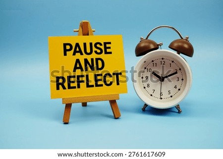 Pause And Reflect text with alarm clock on blue background