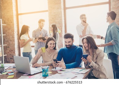 Pause For Relax At Work. Happy Work Team During Break Time In Light Modern Office, Talking, Having Drinks, Smiling, All Dressed In Casual Outfits