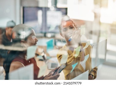 Pave Your Way To Success With Your Vision In Mind. Shot Of Two Businesswomen Brainstorming With Notes On A Glass Wall In An Office.