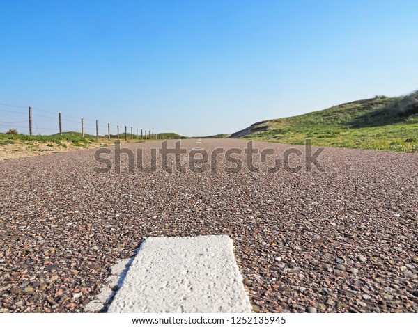Paved cycle track with\
dividing line in the Amsterdam water supply dunes near to Amsterdam\
and Zandvoort