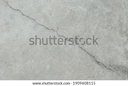 Paved floor outside the building with a long crack.
