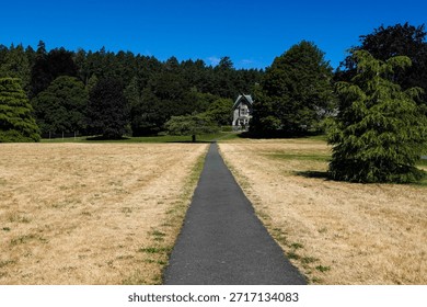 Paved path leading through open grassy park