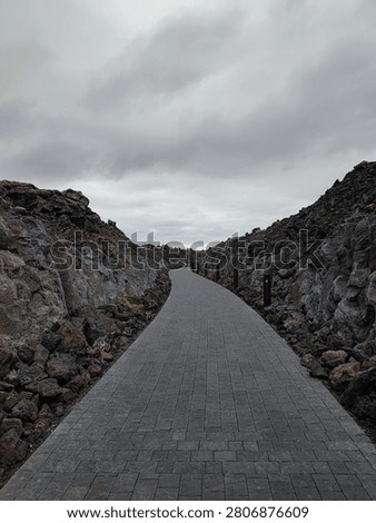 Paved pathway leading through lava rock formations to Blue Lagoon, Iceland