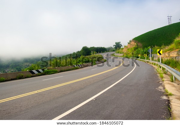 Paved road curve on mountains.Road dividing\
line.The road to the\
mountain.