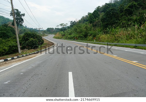 Paved road curve\
on mountains.Road dividing line.The road to the mountain.The\
asphalt road on both\
sides.