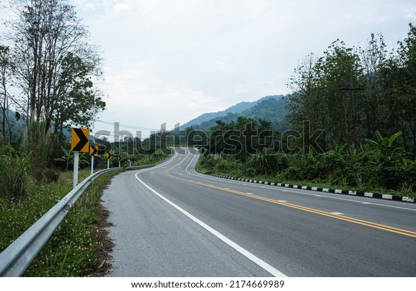Paved road curve\
on mountains.Road dividing line.The road to the mountain.The\
asphalt road on both\
sides.