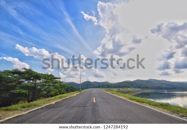 Paved roads,
mountains and skies/The road on the dam/Path to holiday
travel/Empty road And the sky is
clear.