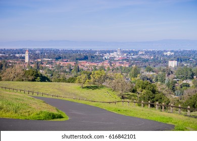 Paved running trail on the Standford dish surrounding hills; Stanford campus, Palo Alto and Silicon Valley skyline in the background, San Francisco bay area, California