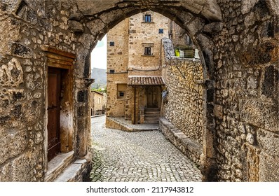A paved street with an arch in a medieval town. Arch on paved street. Medieval arch on paved street. Paved street arch