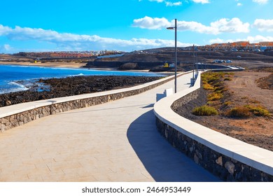 A paved walkway in Fuerteventura, Canary Islands, overlooking the Atlantic Ocean. Paved walkway winding along coastline - Powered by Shutterstock