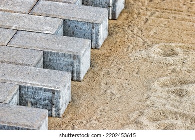 Pavement repairs and paving slabs laying on the prepared surface, with tile cubes in the background. Laying paving slabs in the pedestrian zone of the city. Paving slabs and curbs - Shutterstock ID 2202453615