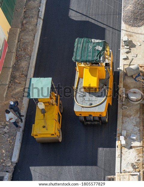 Paving machine compacting asphalt on the road.\
Pneumatic Tire Roller and Steel Wheel Roller at work.  Road surface\
repair.  Top view.
